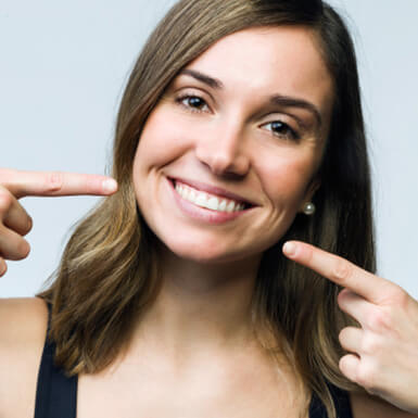 smiling woman pointing to her teeth