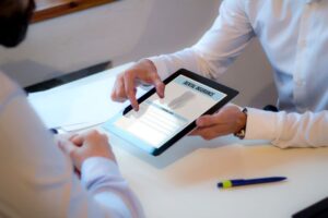 Two people looking at dental insurance form displayed on tablet